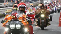 Sejumlah pengendara motor gede mengenakan kostum Santa Claus dan rusa di kota Tokyo, Jepang, (23/12). Touring ini dinamakan "Toy Run" yang diselenggarakan oleh komunitas Harley Santa Club. (AFP PHOTO/Toru Yamanaka)