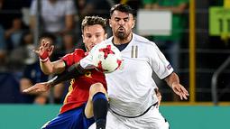 Gelandang Spanyol, Saul Niguez,berebut bola dengan striker Italia, Andrea Petagna, pada laga semifinal Piala Eropa U-21 di Stadion Miejski, Polandia, Selasa (27/6/2017). Spanyol menang 3-1 atas Italia. (AFP/Janek Skarzynski)