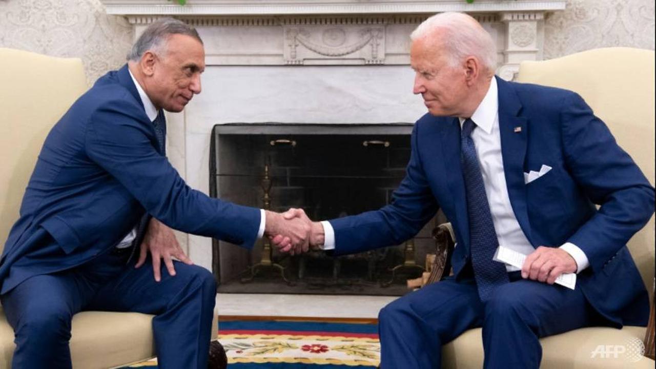 Presiden AS Joe Biden berjabat tangan dengan Perdana Menteri Irak Mustafa Al-Kadhimi (kiri) di Kantor Oval Gedung Putih.  (AFP/SAUL LOEB)