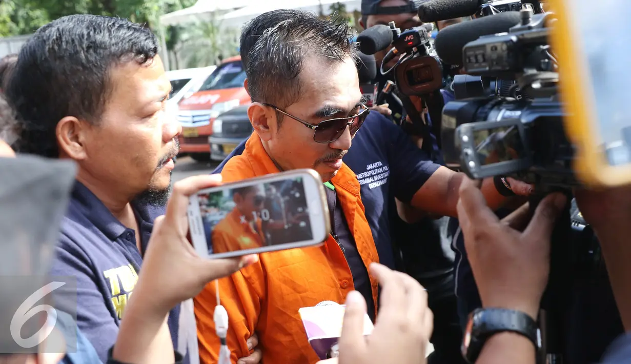 Gatot Brajamusti dimintai keterangan para awak media saat di Polda Metro untuk menjalani pemekrisaan, Jakarta, Selasa (25/10). Gatot menjalani pemeriksaan terkait kepemilikan senjata api dan amunisi ilegal. (Liputan6.com/Herman Zakharia)