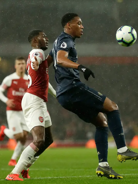 Striker Manchester United, Anthony Martial berusaha mengontrol bola dari kawalan pemain Arsenal, Ainsley Maitland-Niles selama pertandingan lanjutan Liga Inggris di Stadion Emirates di London (10/3). Arsenal menang 2-0 atas MU. (AP Photo/Tim Ireland)