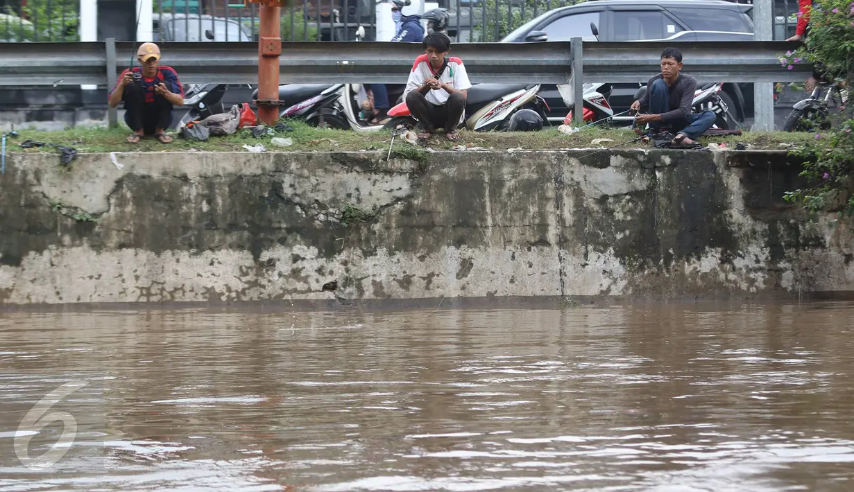 Sejumlah warga memancing ikan di bantaran Sungai Ciliwung, Jakarta, Selasa (21/2). Meluapnya Sungai Ciliwung menjadi berkah tersendiri bagi warga untuk memancing dan menjala ikan yang terbawa arus dari hulu. (Liputan6.com/Immanuel Antonius)
