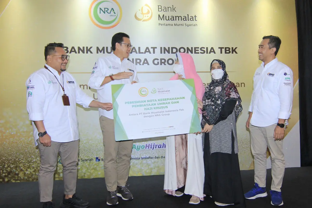 Direktur Utama PT Bank Muamalat Indonesia Tbk  Achmad K. Permana (kedua kiri) berbincang dengan Founder NRA Group Irmawati Mochtar (tengah) dalam peresmian pembiayaan haji khusus (Prohajj Plus) dan umrah kepada NRA Group di Muamalat Tower pada Kamis, (13/