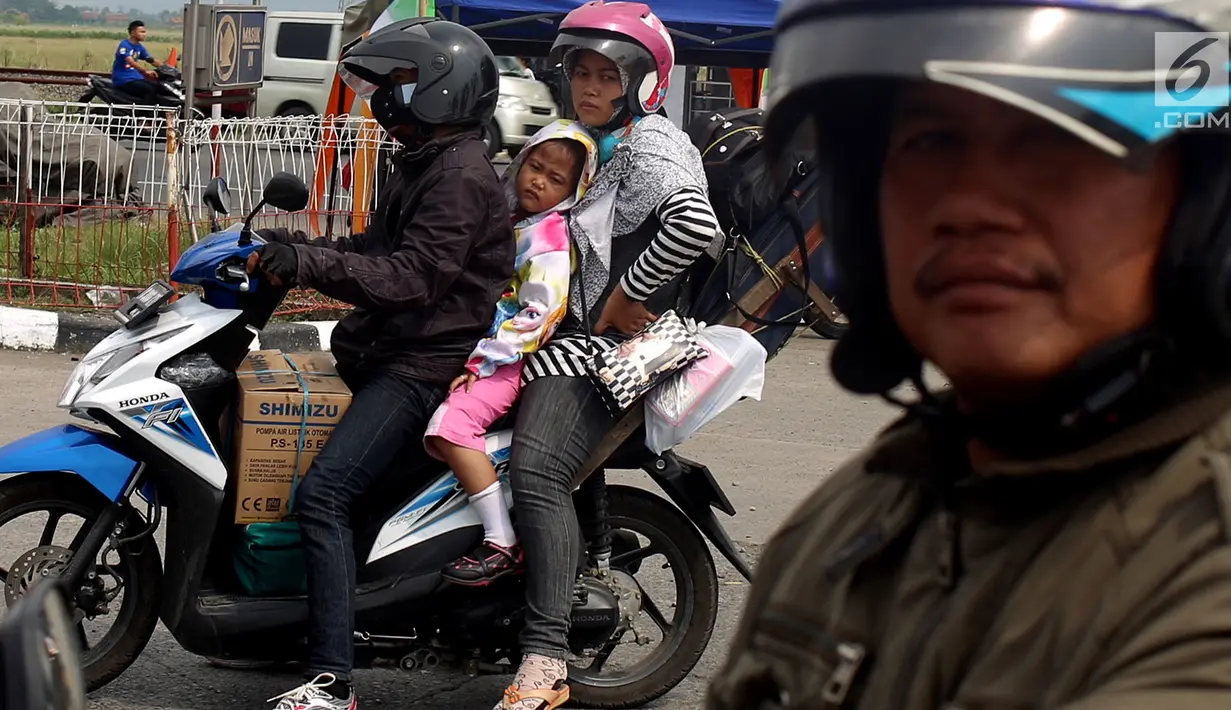 Pemudik sepeda motor dengan membawa anak mengantre untuk mengisi bahan bakar di SPBU kawasan Pantura di wilayah Brebes, Jawa Tengah, Kamis (22/6). Meski berbahaya, sejumlah pemudik masih nekat membawa anak mereka dengan motor. (Liputan6.com/Johan Tallo)