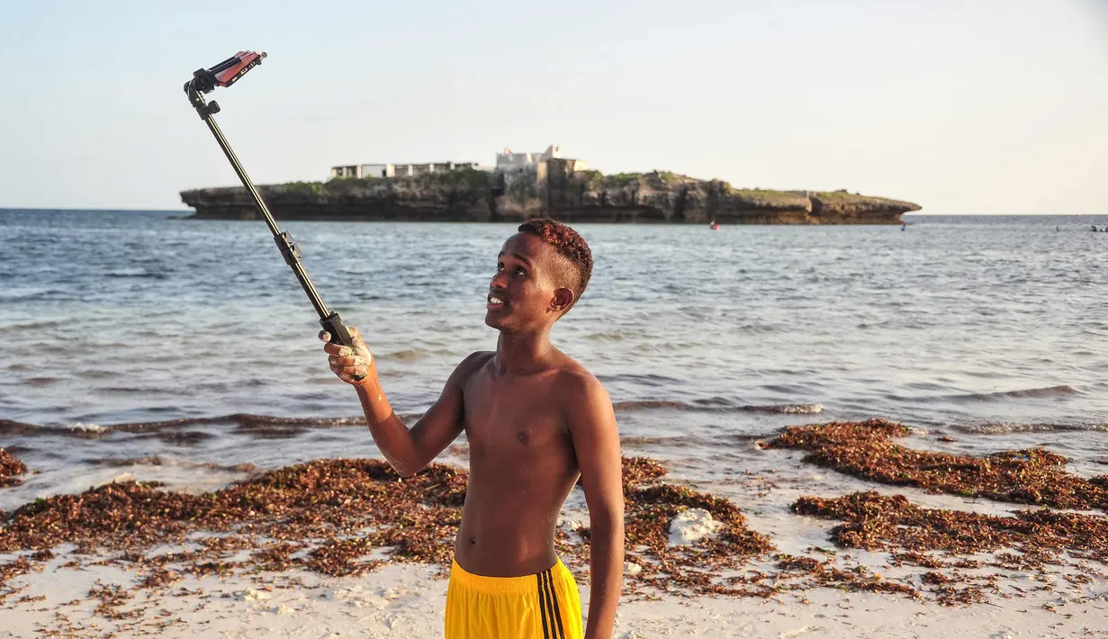Seorang pria berselfie di Pantai Jazera di pinggiran Mogadishu, Somalia (24/11). Pantai ini jadi tempat rekreasi populer bagi warga Somalia. (AFP Photo/Mohamed Abdiwahab)