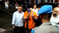 Penampakan mantan Kapolda Sumbar Irjen Teddy Minahasa memakai baju tahanan berwarna oranye dengan tangan diborgol saat dijebloskan ke Rutan Polda Metro Jaya. (Merdeka.com)