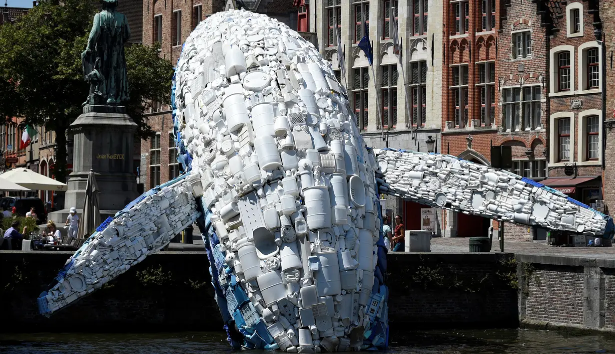 Sebuah instalasi patung paus terbuat dari 5 ton sampah plastik yang ditampilkan di sungai Brugges, Belgia, Sabtu (14/7). Patung paus tersebut bertujuan untuk menyoroti ancaman yang diakibatkan oleh penggunaan plastik secara besar-besaran. (AFP/JOHN THYS)