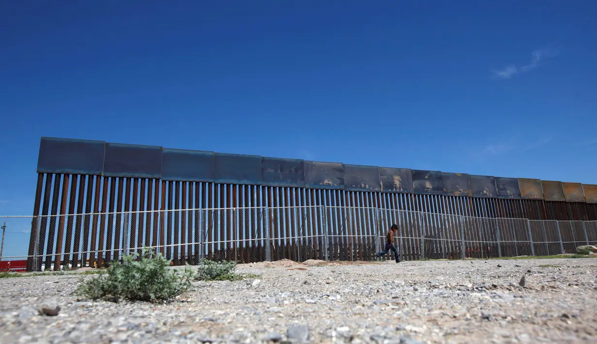 Seorang anak melintasi pagar pembatas yang merupakan bagian dari dinding perbatasan AS-Meksiko di Sunland Park, AS (09/9). Amerika Serikat dan Mexico merupakan dua negara yang memiliki batas geografis yang berdekatan. (REUTERS/Jose Luis Gonzalez)