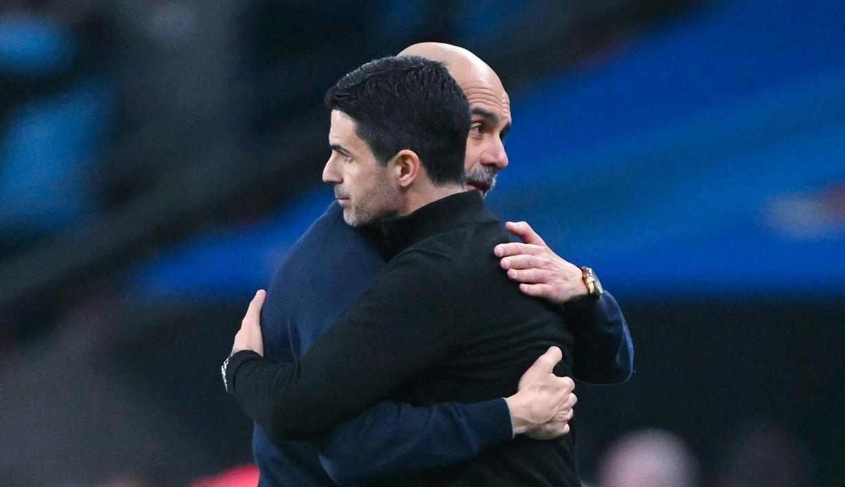 Pelatih Manchester City, Pep Guardiola memeluk pelatih Arsenal, Mikel Arteta, setelah laga final Carabao Cup di Stadion Wembley, Minggu (22/3/2026). (AFP/Glyn Kirk)