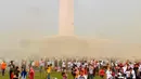 Suasana saat warga bermain serbuk warna-warni saat Festival Damai Millenial Road Safety di Monas, Jakarta, Minggu (23/6/2019). Serbuk warna-warni yang ditembakkan oleh meriam menambah kemeriahan Festival Damai. (merdeka.com/Iqbal Nugroho)