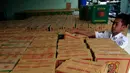 Seorang petugas menata kardus barang bukti jamu kemasan botol di kantor BPOM Yogyakarta, Rabu (30/3/2016). BPOM Yogyakarta berhasil mengamankan 1.800 kardus jamu tradisional tanpa izin edar. (Foto: Boy Harjanto)