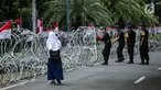 Personel Brimob memasang kawat berduri di sekitar area gedung KPU, Jakarta, Jumat (1/3). Kawat berduri itu untuk mengantisipasi massa Forum Umat Islam (FUI) dan Gerakan Jaga Indonesia yang akan menggelar aksi di depan KPU. (Liputan6.com/Faizal Fanani)