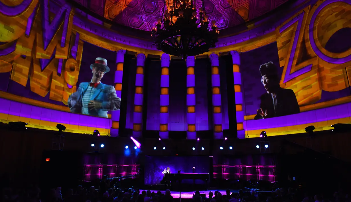 Suasana saat musikus Elton John tampil bernyanyi sambil bermain piano sebelum mengadakan konferensi pers di New York (24/1). Elton John mengatakan alasan pensiun dari tur adalah ingin berfokus pada keluarganya. (AFP/Timothy A. Clary)