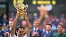Petenis Swiss, Roger Federer mengangkat trofi kemenangan dihadapan penonton setelah mengalahkan petenis Kroasia, Marin Cilic pada pertandingan final tunggal putra Kejuaraan Wimbledon 2017 di Wimbledon, London. (16/07). (AFP Photo / Glyn Kirk)