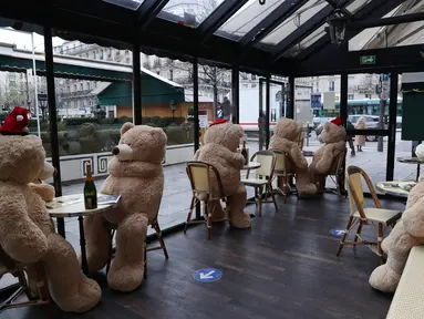 Sejumlah boneka beruang raksasa terlihat di kafe Les Deux Magots yang ditutup di Paris, Prancis pada 16 Desember 2020. Otoritas kesehatan Prancis pada Rabu (16/12) melaporkan 17.615 kasus infeksi COVID-19 tambahan dalam 24 jam terakhir, penambahan harian terbesar sejak 21 November. (Xinhua/Gao Jing)