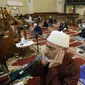 Yusuf Omar melakukan adzan sebelum melaksanakan tarawih pada malam pertama bulan suci Ramadhan di Pusat Komunitas Muslim Chicago, Senin (13/4/2021). (AP Photo/Shafkat Anowar)