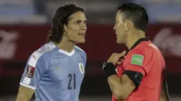 Penyerang Uruguay, Edinson Cavani, berbicara dengan wasit usai diganjar kartu merah saat menghadapi Brasil pada laga lanjutan kualifikasi Piala Dunia zona CONMEBOL di Estadio Centenario, Rabu (18/11/2020) pagi WIB. Brasil menang 2-0 atas Uruguay. (AFP/Raul Martinez/pool)