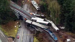 Pemandangan dari udara memperlihatkan Kereta Amtrak usai kecelakaan di Interstate di DuPont, Washington, AS (18/12). Lima kendaraan dan 2 truk semi trailer yang tengah melintas ketabrak kereta tersebut. (AP Photo/John Froschauer)