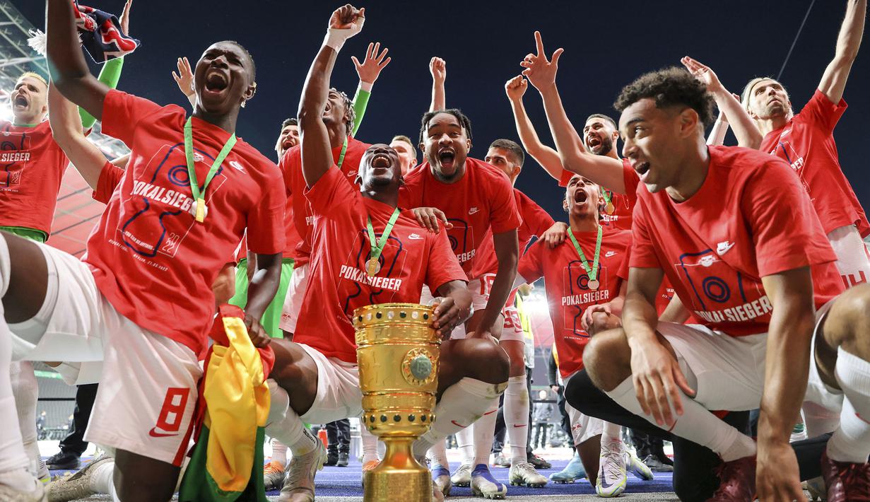 Pemain Leipzig merayakan kemenangan bersama trofi DFB Pokal atau Piala Liga Jerman usai mengalahkan SC Freiburg pada partai final yang berlangsung di Stadion Olimpiade di Berlin, Jerman, Sabtu, 21 Mei 2022 waktu setempat. Die Bullen berhasil menang lewat babak adu penalti dengan skor 4-2 usai laga berjalan imbang 1-1. (DPA via AP/Jan Woitas)