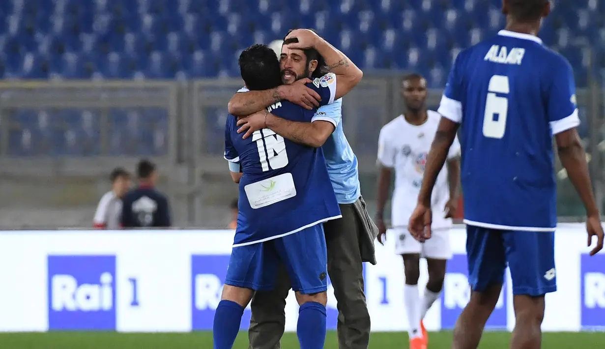 Seorang penggemar memeluk Diego Armando Maradona di tengah lapangan pada laga amal bertajuk 'United for Peace', di Stadion Olimpico, Roma, Kamis (13/10/2016) dini hari WIB. (EPA/Alessandro Di Meo)