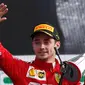 Pembalap Ferrari Charles Leclerc memegang piala sambil melambaikan tangan usai memenangkan F1 GP Italia 2019 di Sirkuit Monza, Minggu (8/9/2019). Leclerc menjuarai F1 GP Italia 2019 setelah pertarungan alot melawan duo pembalap Mercedes, Lewis Hamilton dan Valtteri Bottas. (AP Photo/Antonio Calanni)