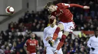 James Garner dari Nottingham Forest menyundul bola di depan pemain Arsenal Martin Odegaard selama pertandingan sepak bola putaran ketiga Piala FA Inggris antara Nottingham Forest dan Arsenal di City Ground, Nottingham, Inggris, Minggu, 9 Januari 2022. (AP