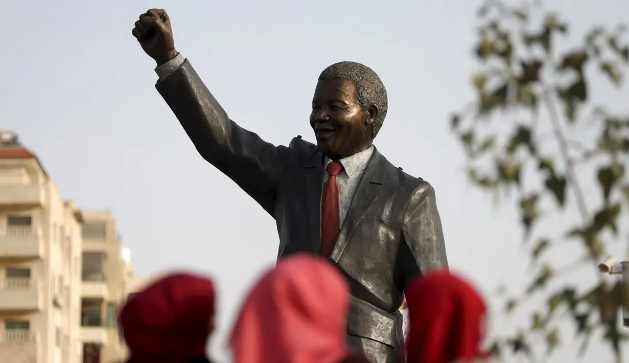 Patung tokoh revolusi dunia asal Afrika Selatan, Nelson Mandela berdiri tegak di kota Ramallah, Palestina, Selasa (26/4). Patung dengan tangan kanan mengepal ke udara itu menjulang dengan ketinggian enam meter dan bobot dua ton. (REUTERS/Mohamad Torokman)