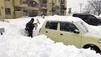 Seorang pria tengah membersihkan mobilnya yang terkubur salju di kota Hokkaido, Jepang (Dok. Sky News)