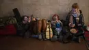 Orang-orang beristirahat di kereta bawah tanah Kiev, menggunakannya sebagai tempat perlindungan bom di ibu kota Ukraina, Kamis, 24 Februari 2022. Warga di Kiev tampak berlindung di stasiun bawah tanah kota dan tempat-tempat aman lainnya untuk menghindari invasi Rusia. (AP Photo/Emilio Morenatti)