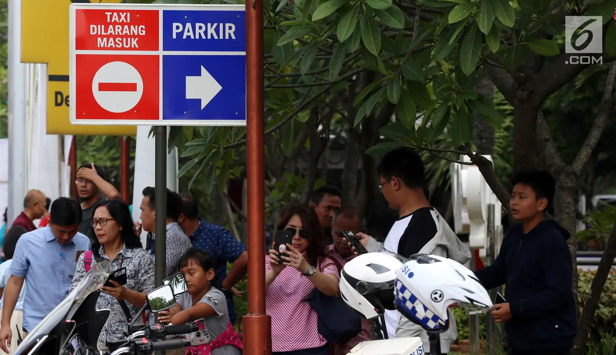Warga antusias melihat iring-iringan rombongan Presiden Amerika Ke-44 Barack Obama saat menuju Bandara Halim Perdanakusuma Jakarta, Minggu (2/7). Obama dan keluarga mengakhiri masa liburannya di Indonesia pada siang ini. (Liputan6.com/Johan Tallo)
