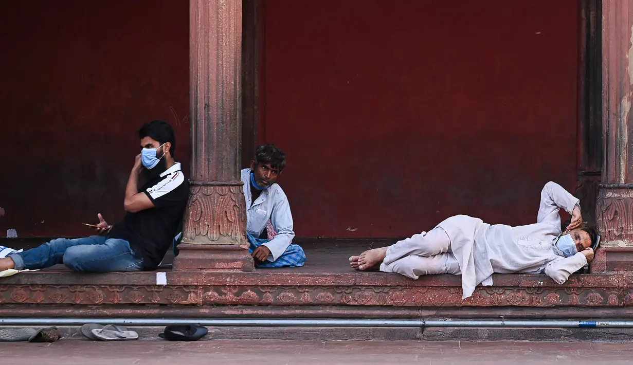 Umat Muslim menunggu di masjid Jama Masjid sebelum berbuka puasa pada hari pertama bulan suci Ramadhan, di New Delhi (14/4/2021). Masjid Jama atau Masjid-i Jahān-Numā merupakan masjid utama yang berada di kawasan Delhi Tua di India. (AFP/Prakash Singh)