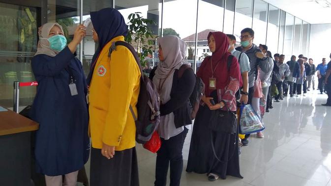 Petugas kesehatan memeriksa suhu tubuh seluruh pekerja dan tamu yang akan masuk ke Kantor Pusat Pertamina di Jalan Merdeka Timur Jakarta. (Dok Pertamina)