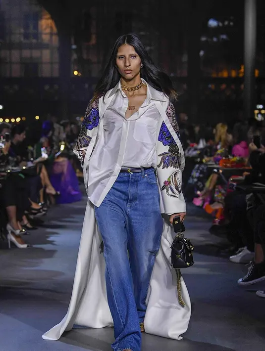 Seperti busana yang dikenakan model ini. Padu padan high waist jeans dengan silk shirt dan outer border. (dok/valentino).