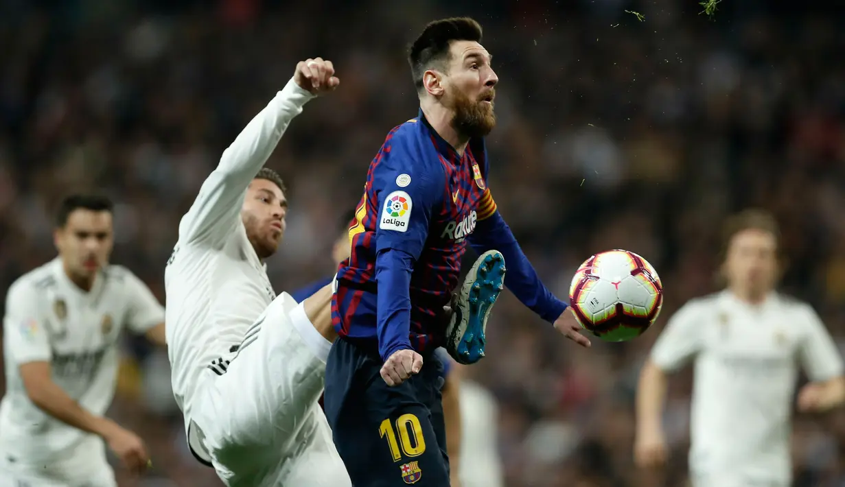 Striker Barcelona, Lionel Messi berusaha membawa bola dari kawalan bek Real Madrid, Sergio Ramos selama pertandingan lanjutan La Liga Spanyol di Santiago Bernabeu, Madrid (2/3). Barcelona menang tipis atas Real Madrid 1-0. (AP Photo/Manu Fernandez)
