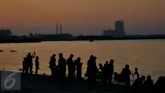 Sejumlah Pengungjung menikmati wisata di pantai Ancol, Jakarta, (31/12). Pemprov DKI Jakarta menyarankan untuk warga Jakarta yang ingin merayakan malam pergantian tahun di pusatkan di Pantai Ancol. (Liputan6.com/Gempur M Surya)