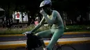 Seorang pria mengendarai sepeda dengan tubuh di cat serta telanjang saat mengikuti World Naked Bike Ride di Guadalajara, Jalisco, Meksiko (17/6). Acara ini digelar untuk memprotes polusi gas emisi dari mobil. (AFP Photo/Hector Guerrero)