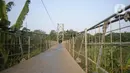 Suasana jembatan gantung di Kelurahan Curug, Bojongsari, Kota Depok, Jawa Barat, Senin (24/8/2020). Setiap sore, warga sekitar bermain di jembatan tersebut sambil menikmati matahari tenggelam. (merdeka.com/Dwi Narwoko)