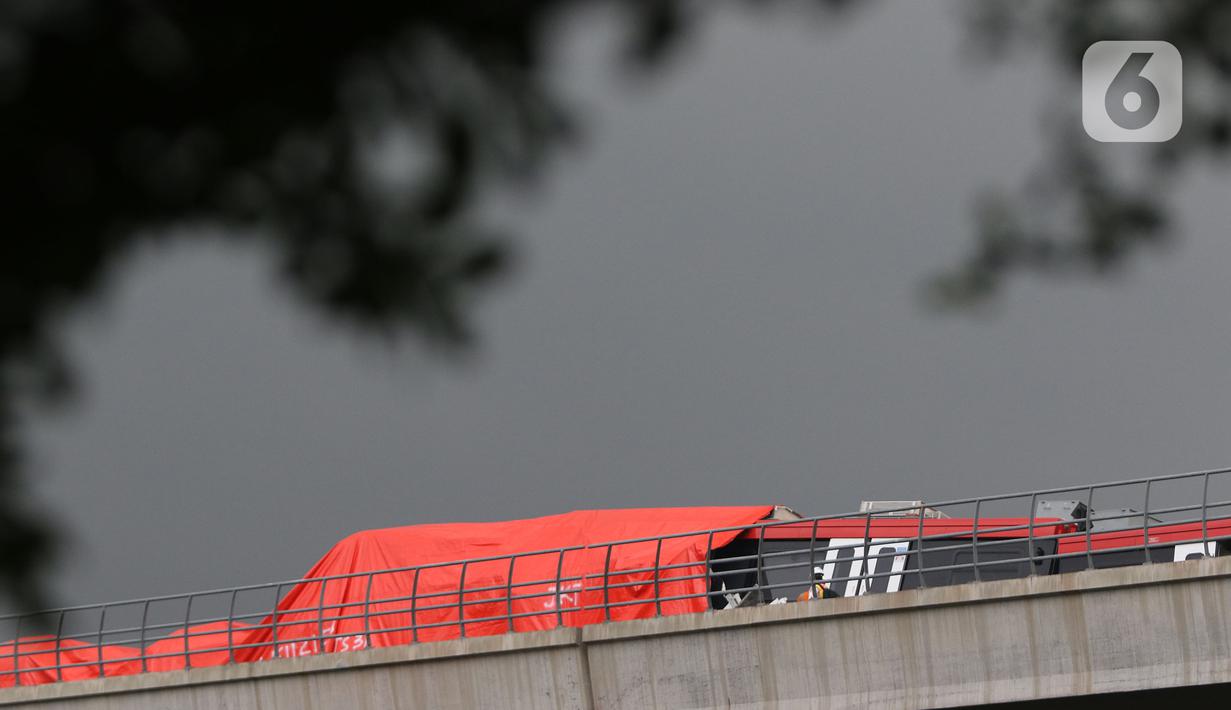 Petugas mengecek kereta ringan lintas rel terpadu (LRT) Jabodebek yang mengalami kecelakaan di jalur lintas LRT Cibubur, Jakarta Timur, Senin (25/10/2021). Dua kereta LRT tersebut sedang uji coba saat tabrakan terjadi sehingga gerbong kosong. (Liputan6.com/Herman Zakharia)