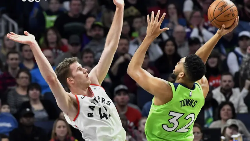 Karl-Anthony Towns memasukkan bola saat Timberwolves melawan Raptors (AP)