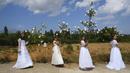 La Doncellas (gadis) berpakaian pengantin putih dikelilingi oleh bunga saat mengambil bagian dalam ziarah The Maidens di Sorzano, Spanyol, 15 Mei 2022. Menurut tradisi kuno, ziarah The Maidens bertujuan untuk menghormati musim semi dan kesuburan wanita. (AP Photo/Alvaro Barrientos)