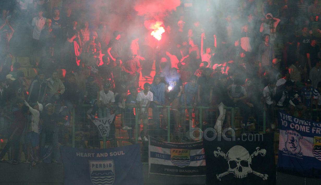 Bobotoh menyalakan flare saat Persib Bandung melawan Bhayangkara FC pada laga Liga 1 2017 di Stadion Patriot, Bekasi, Minggu (04/06/2017). (Bola.com/Nicklas Hanoatubun)