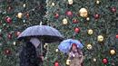 Orang-orang berjalan saat salju turun di Madrid, Spanyol, Jumat (8/1/2021). Badai Filomena mengakibatkan salju lebat turun di Madrid dan seluruh Spanyol. (GABRIEL BOUYS/AFP)