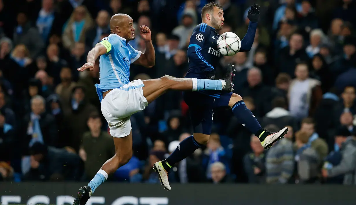 Bek City, Vincent Kompany (kiri) berusaha mengambil bola dari penyerang Real Madrid, Jese pada leg pertama Semifinal Liga Champions di stadion Etihad, Inggris, (27/4). Real Madrid bermain imbang dengan City dengan skor 0-0. (Reuters/Phil Noble)