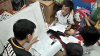 Guru relawan memberikan materi pelajaran kepada anak-anak di Sekolah Komunitas Jendela, Jakarta, Minggu (25/11). Sekolah yang berdiri sejak 2012 dibimbing oleh mahasiswa dan pekerja kantoran. (merdeka.com/Iqbal S. Nugroho)