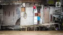 Warga permukiman bantaran Sungai Ciliwung menyaksikan banjir, Jakarta, Senin (10/10/2022). Hingga pukul 09.00 WIB hari ini, Badan Penanggulangan Bencana Daerah (BPBD) DKI Jakarta mencatat sebanyak 68 RT di Jakarta terendam banjir akibat luapan Sungai Ciliwung. (Liputan6.com/Faizal Fanani)