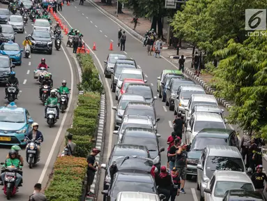 Sejumlah mobil pengemudi online menutup jalur lambat saat mereka menggelar demo di kantor pusat Grab kawasan Kuningan, Jakarta, Senin (29/10). Akibat aksi tersebut, kemacaten parah terjadi dari arah Mampang menuju Menteng. (Liputan6.com/Faizal Fanani)