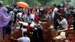 Proses penguburan massal korban kecelakaan bus di Tanjakan Emen Subang di TPU Legoso Ciputat, Tangerang Selatan, Banten, Minggu (11/2). Sebanyak 26 korban dimakamkan di TPU Legoso ini. (Liputan6.com/JohanTallo)