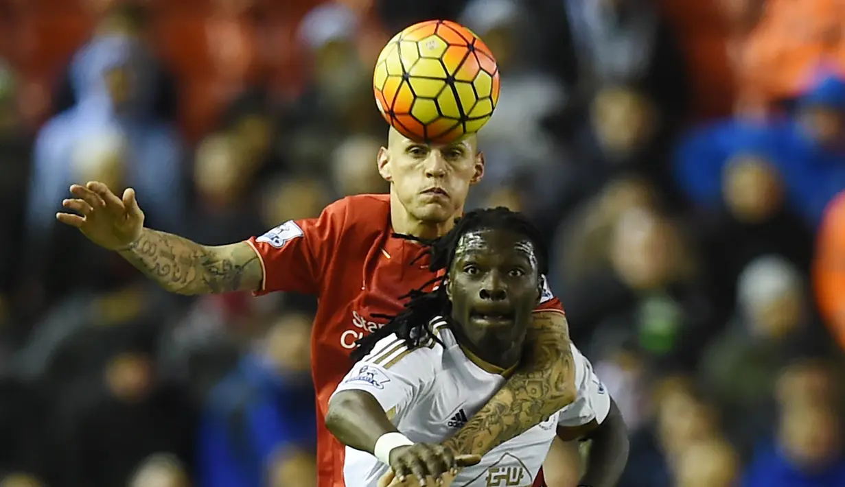 Pemain Liverpool, Martin Skrtel (kiri) berebut bola dengan pemain Swansea City, Bafetimbi Gomis pada lanjutan Liga Premier Inggris antara Liverpool vs Swansea City di Stadion Anfiled, Senin (30/11/2015) dini hari WIB. (AFP Photo/Paul Ellis)
