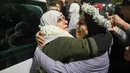 Tahanan Palestina, Baraah Fuqaha (kanan) disambut oleh kerabatnya pada saat kedatangan pada dini hari tanggal 20 Januari 2025 di kota Tepi Barat yang diduduki, Beitunia, di pinggiran kota Ramallah. (Zain JAAFAR/AFP)