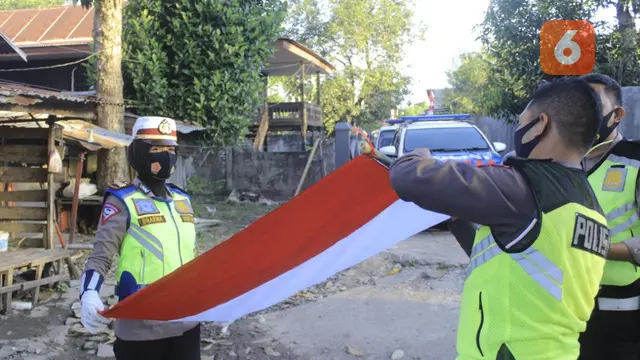AKP Dharmawaty membagikan bendera kepada warga miskin (Fauzan/Liputan6.com)
